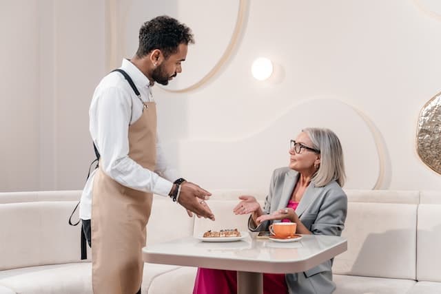 Waiter standing over annoyed customer